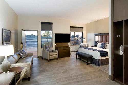 a hotel room with a bed and a couch at ClubHouse Hotel Sioux Falls in Sioux Falls