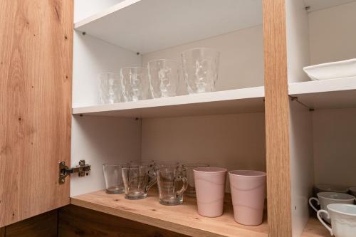 a cupboard with many glass vases on it at HH apartments in Bjelašnica