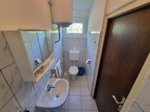 a small bathroom with a sink and a toilet at Guest House Morska Grota in Povile