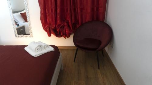 a chair in a room with a red curtain at M&G holiday house in Matera