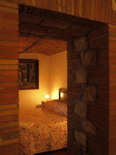 a bedroom with a bed and a brick wall at Agriturismo Podere 3 Querce in Manciano
