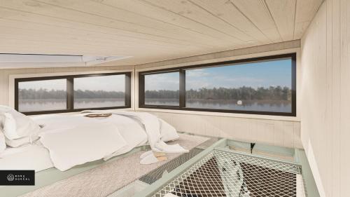 ein Schlafzimmer in einem Boot mit einem Bett und Fenstern in der Unterkunft MiniBora Le marin - Cantons-de-l'Est in Bury
