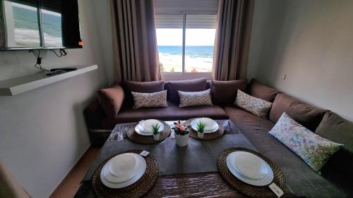 a living room with a couch and a table with plates on it at Apartamento Vista Mar in Martil