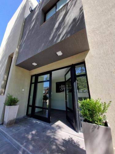 a building with glass doors and potted plants in front at Aires de las Sierras in Sierra de la Ventana