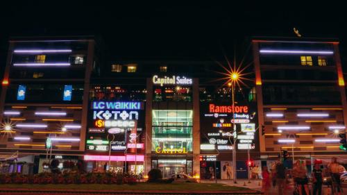 een groep gebouwen met neonborden 's nachts bij Capitоl Suites in Skopje