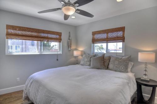 een slaapkamer met een bed en een plafondventilator bij Unit B 3bd2ba Condo, Steps To The Sand & Pier! in Newport Beach
