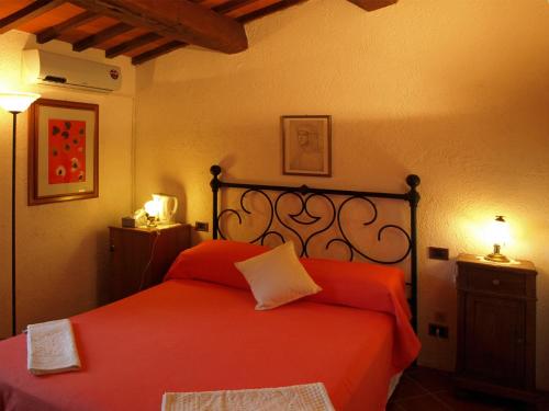a bedroom with a red bed with two pillows at Agriturismo Podere 3 Querce in Manciano