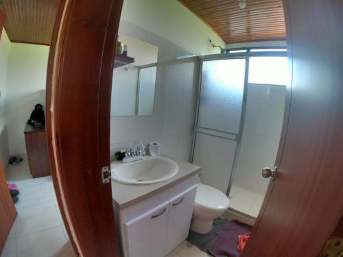 La salle de bains est pourvue d'un lavabo, d'une douche et de toilettes. dans l'établissement Hermosa Finca El Porvenir, à Tibasosa