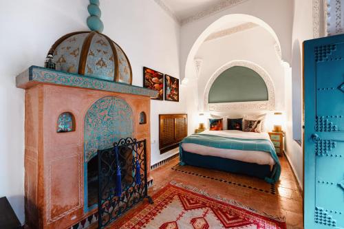 een slaapkamer met een bed en een open haard bij Riad Dar Alhambra in Marrakesh