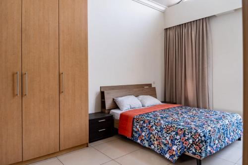 a small bedroom with a bed and a cabinet at Unit 14, Capella Place in East Legon