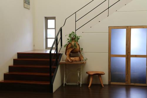 a staircase with a plant on a table next to a door at Romeo B&B in Taitung City