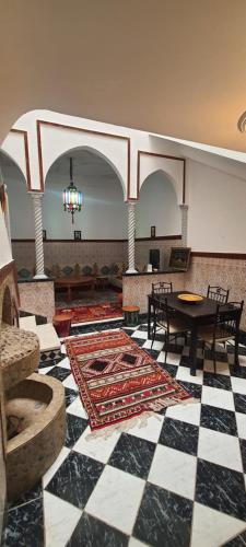 een kamer met een geruite vloer met een tafel en stoelen bij Quariya Assiyahiya Riad Camilia in Marrakesh