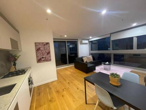 a kitchen and living room with a table and a couch at Nest Apartments on Rose Lane in Melbourne