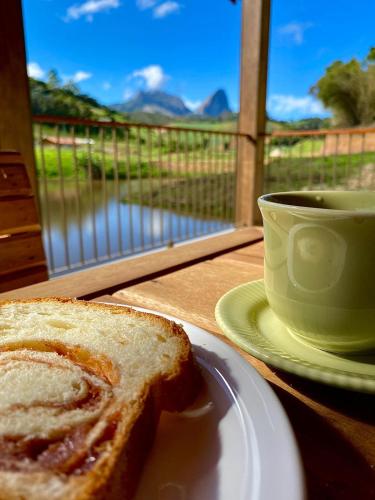 een stuk brood op een bord naast een kopje koffie bij Pousada Rural Recanto do Lago in Pedra Azul