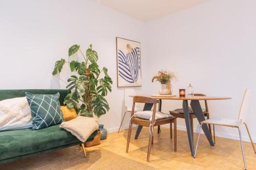 un salon avec un canapé vert et une table dans l'établissement Beautiful 1BD Apartment Issy-les-Moulineaux!, à Issy-les-Moulineaux