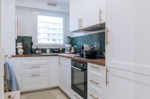 a kitchen with white cabinets and a window at Beautiful 1BD Apartment Issy-les-Moulineaux! in Issy-les-Moulineaux