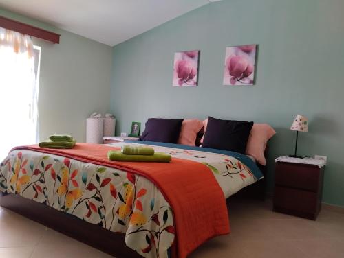 a bedroom with a bed with a colorful blanket at Dhoma romantike , qetesi absolute! in Korçë