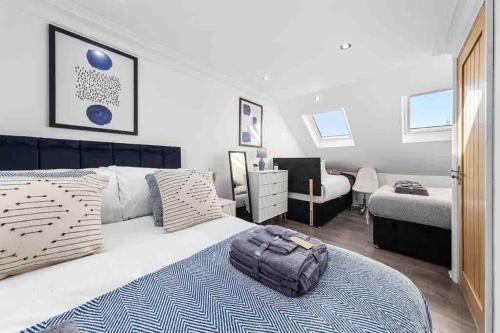Un dormitorio con una cama con una bolsa. en Sleeps 10, CINEMA TV , 2 baths, 10 mins to Stratford, en Ilford