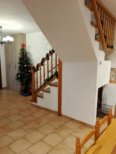 a christmas tree in a living room with a staircase at Cal Massana in Sant Guim de la Plana