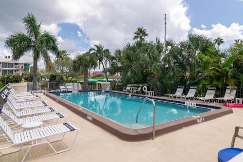 a swimming pool with lounge chairs and a resort at Bridgeport Condo 211 in Bradenton Beach