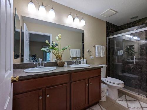 a bathroom with two sinks and a shower and a toilet at Mint Home of Siesta Key's 3/2 & Serene Patio! in Sarasota