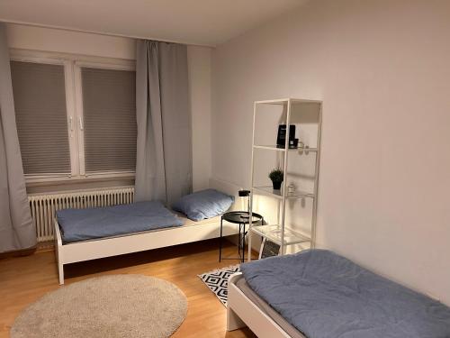 ein Schlafzimmer mit 2 Betten und einem Bücherregal in der Unterkunft 3 Zimmer Wohnung in Dortmund in Dortmund