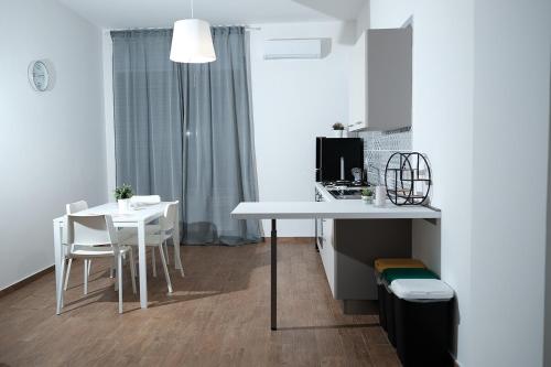 een keuken met een tafel en een tafel en stoelen bij CIVICO 15 APARTMENT in Mercato San Severino