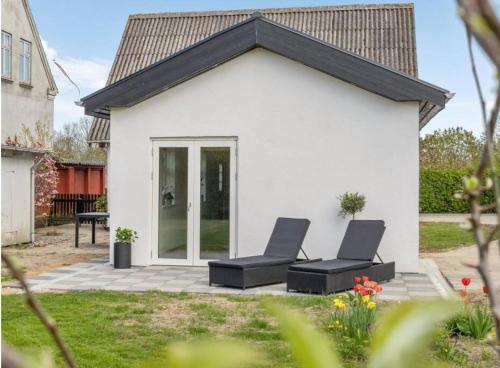 two chairs on a patio in front of a white house at Ingemannsvej 13, Fredericia in Fredericia
