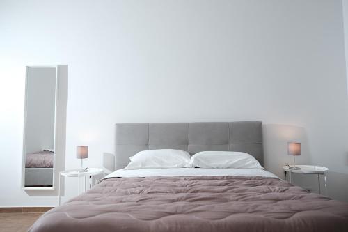 een slaapkamer met een groot bed en 2 tafels bij CIVICO 15 APARTMENT in Mercato San Severino