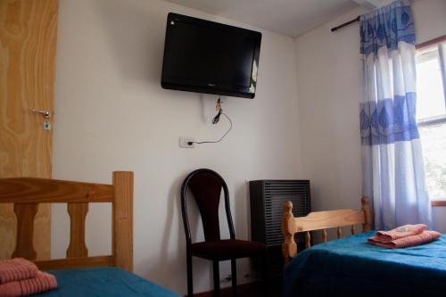 a bedroom with a tv on the wall and a bed at Hope del Bosque in Ushuaia