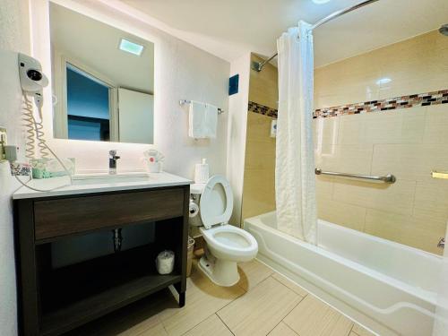 a bathroom with a toilet and a sink and a tub at Comfort Inn & Suites Houston I-10 West Energy Corridor in Houston