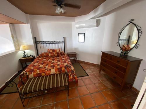 een slaapkamer met een bed, een ladekast en een spiegel bij one beach street hotel -Beach front Spacious 1BD 1BA fabulous view in Zona Romantic Puerto Vallarta in Puerto Vallarta