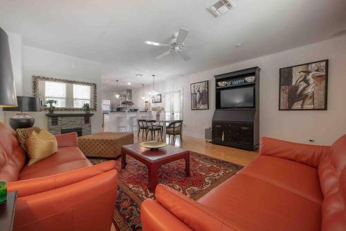 a living room with orange couches and a television at Nawlins vibe with rooftop verandah near Riverwalk and downtown in Tampa