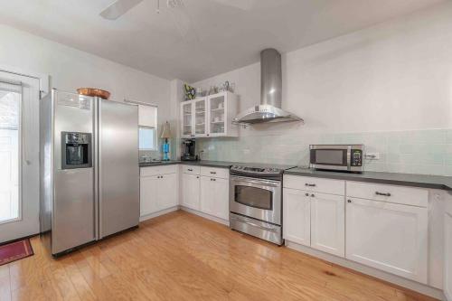 a kitchen with white cabinets and stainless steel appliances at Nawlins vibe with rooftop verandah near Riverwalk and downtown in Tampa
