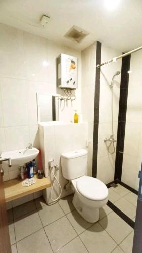 a bathroom with a toilet and a sink at Transit 3jam Apartemen Grand Kamala lagoon bekasi in Pekayon Satu
