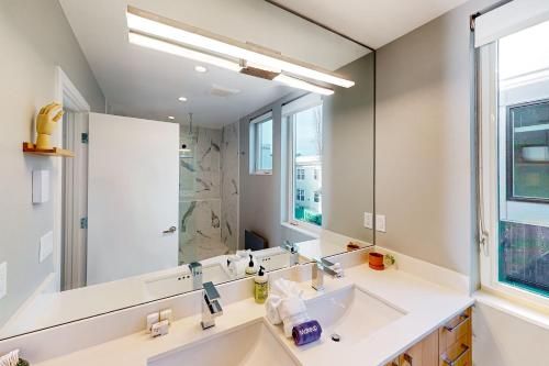 a bathroom with a sink and a large mirror at Luxury Ballard Townhome in Seattle