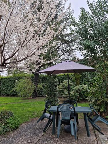 a picnic table with an umbrella and two chairs at LA CASA DI GIM in Lugo
