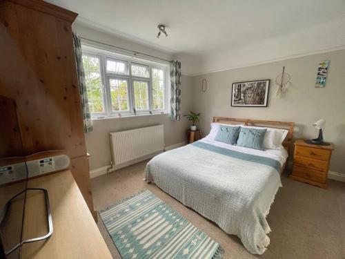 una camera con un grande letto e una finestra di Lavender Oaks Detached Country House a Purley