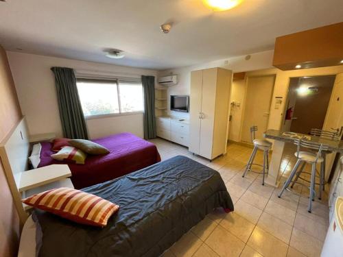 ein Hotelzimmer mit 2 Betten und einer Küche in der Unterkunft complejo miligamapa in Villa Carlos Paz