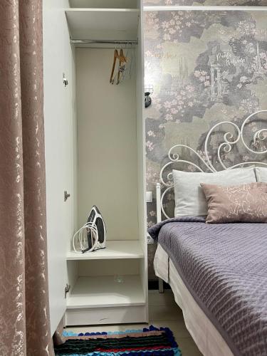 a bedroom with a bed and a wall mural at Уютная комната-студия в центре Бишкека in Bishkek