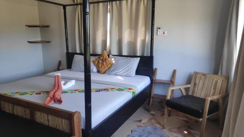 a small bedroom with a bed and a chair at Afiki in Ankwanda