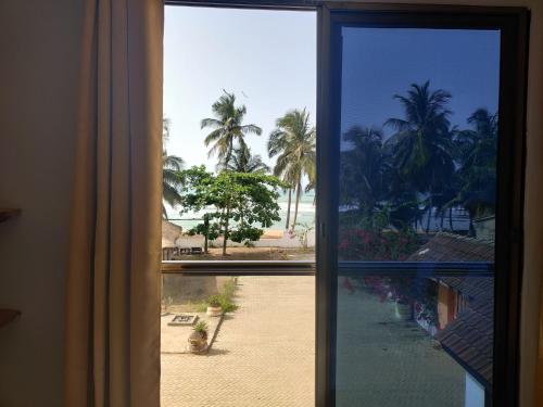 a window with a view of a courtyard with palm trees at Afiki in Ankwanda