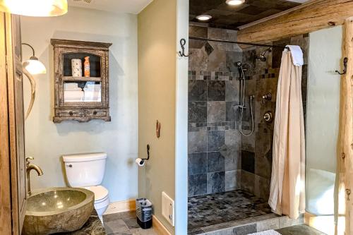 a bathroom with a shower and a toilet and a sink at Poppy's Place Main House in South Fork