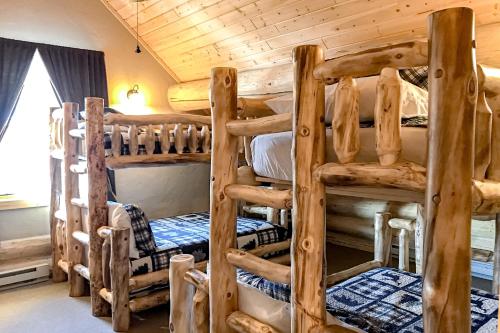 a room with three bunk beds in a log cabin at Poppy's Place Main House in South Fork