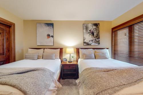 a bedroom with two beds and a table with a lamp at Lion Square Lodge South 550 in Vail