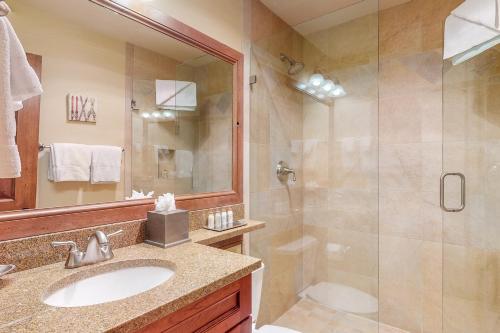 a bathroom with a shower and a sink and a mirror at Lion Square Lodge South 550 in Vail