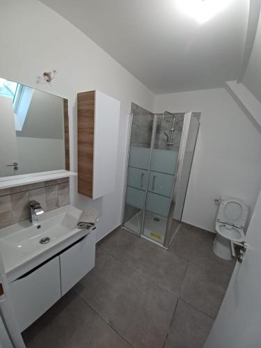 une salle de bain blanche avec un lavabo et une douche dans l'établissement Maison neuf pour 4 personnes 85m2, à Montlouis-sur-Loire