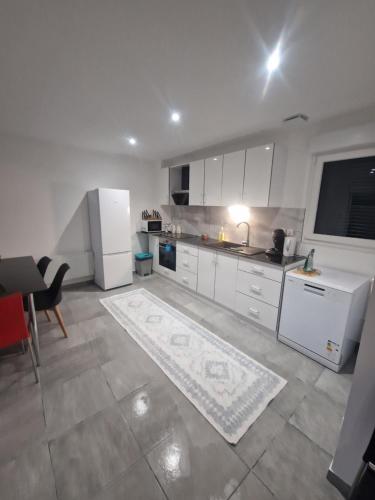 eine Küche mit weißen Schränken und einem weißen Kühlschrank in der Unterkunft Maison neuf pour 4 personnes 85m2 in Montlouis-sur-Loire