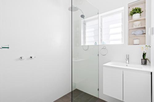 a white bathroom with a shower and a sink at Little Manly 3 Bedroom Sanctuary in Sydney