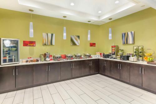 a large kitchen with brown cabinets and a counter at Best Western Plus New Englander in Woburn